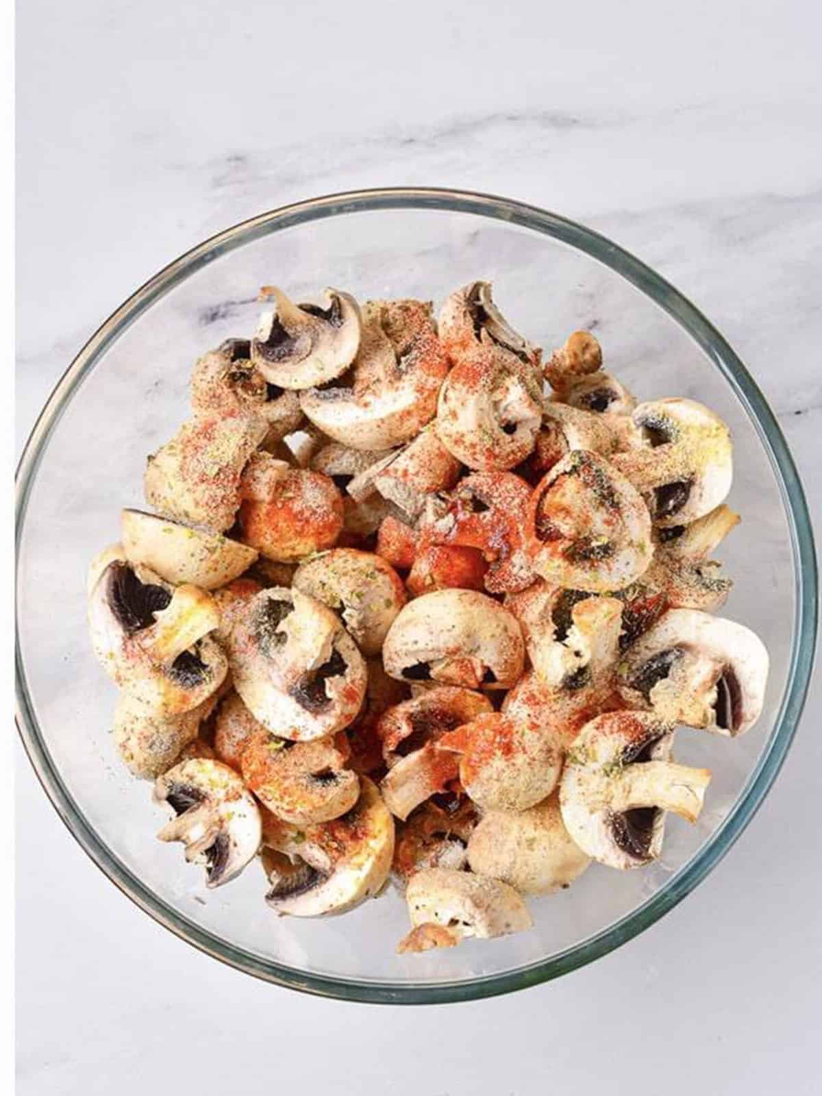 Olive oil, paprika, garlic, and seasonings added on top of the cut mushrooms