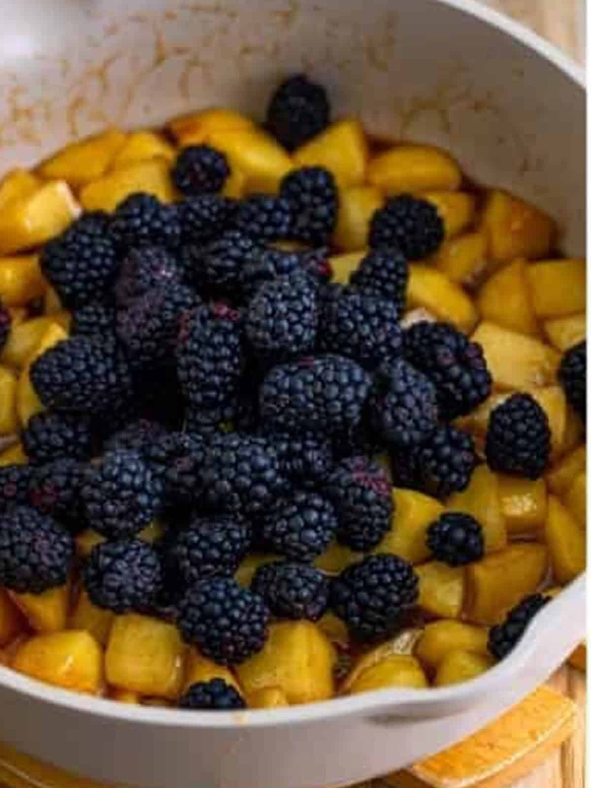 Fresh blackberries added to the cooked apples in the skillet.