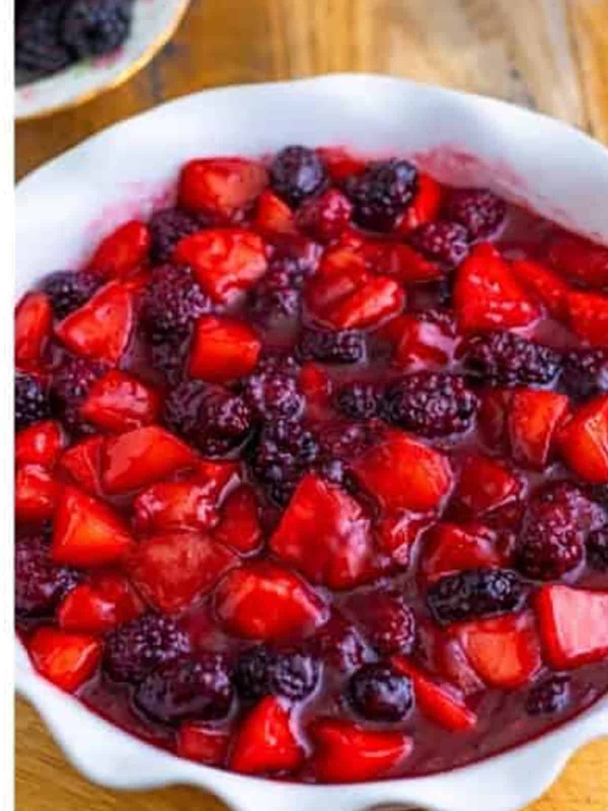 The thickened apple and blackberry filling spread in a baking dish ready for the crumble topping.