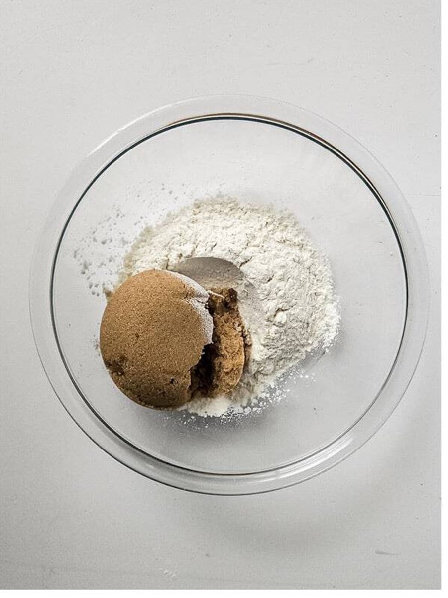 Flour and brown sugar in a glass bowl for the Apple Bread crumble topping.
