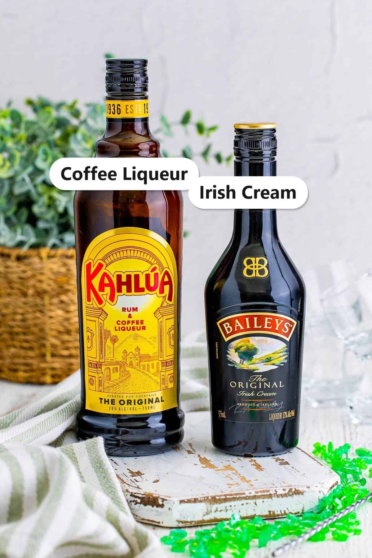 Labeled ingredients for a Baby Guinness shot, a bottle of coffee liqueur and a bottle of Irish cream.