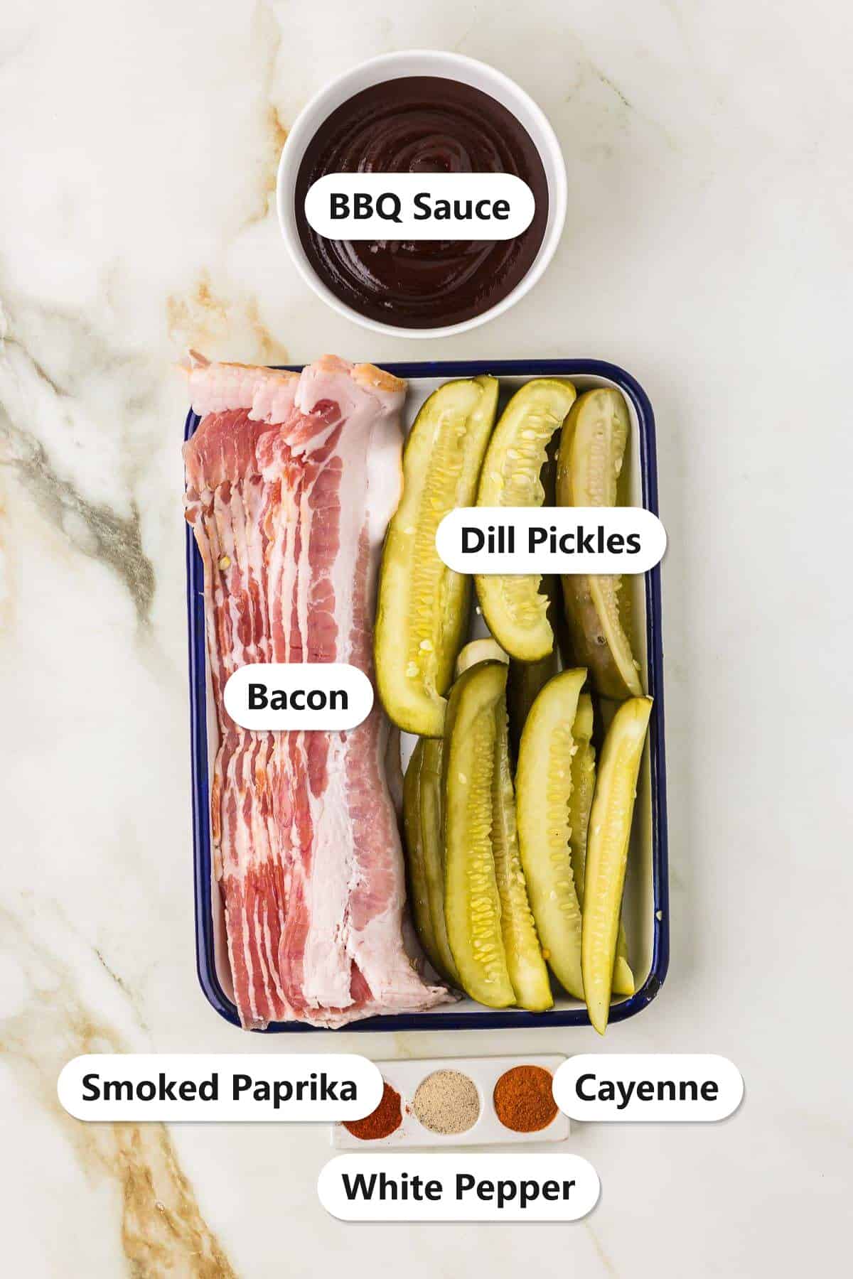 Labeled ingredients for Bacon Wrapped Pickles including dill pickle spears, bacon, BBQ sauce, smoked paprika, cayenne, and white pepper.
