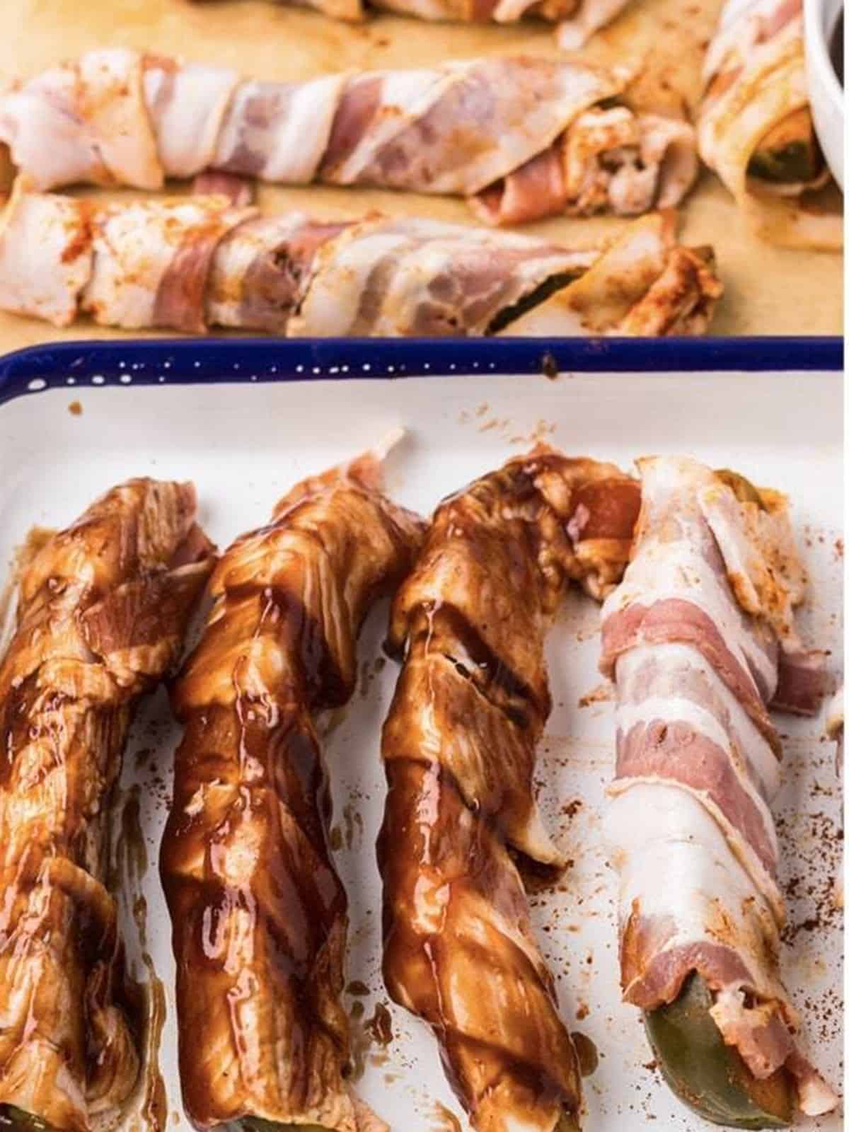 Basting the bacon wrapped pickle spears with BBQ sauce before air frying.