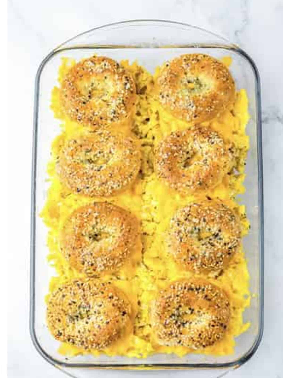 Golden baked bagel breakfast sliders in a baking dish.