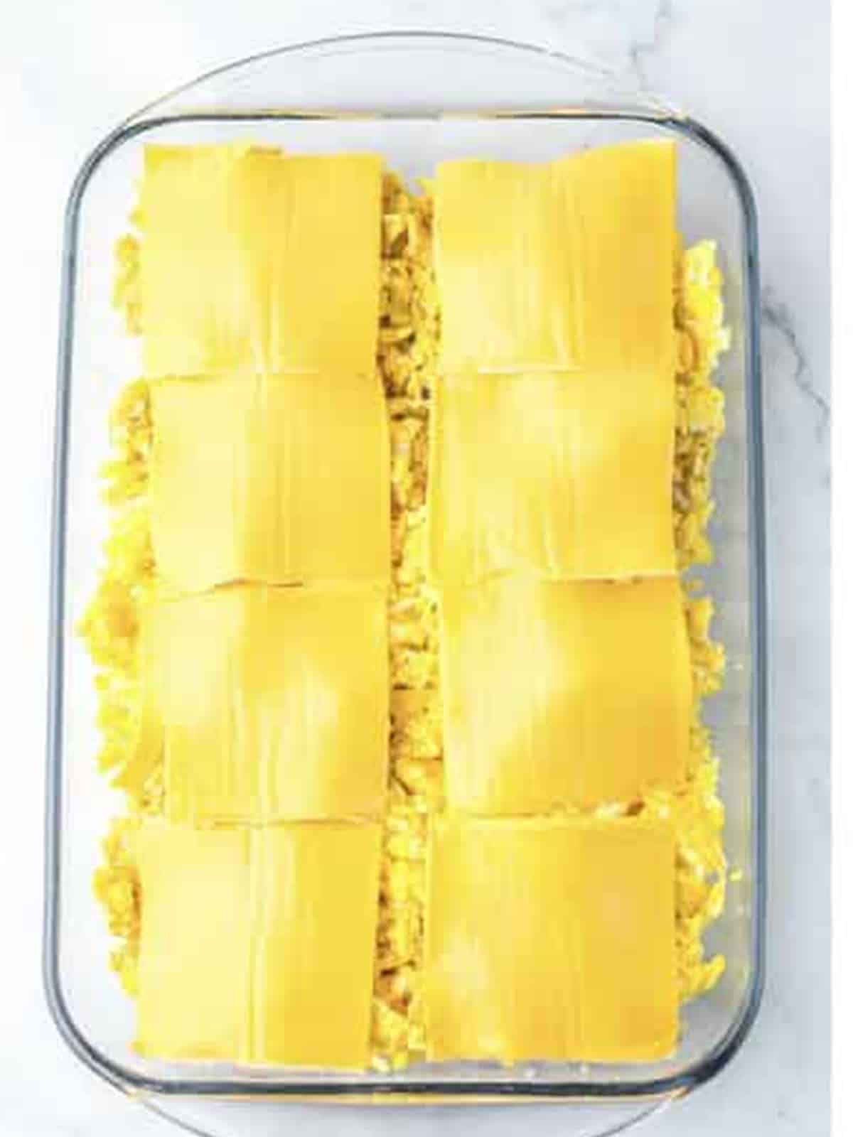 Scrambled eggs and cheese layered over the sausage for breakfast sliders.