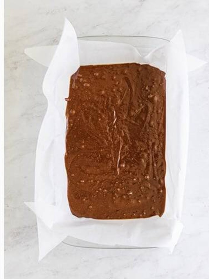 Baileys brownie batter smoothed into a parchment lined 9x13 baking dish.