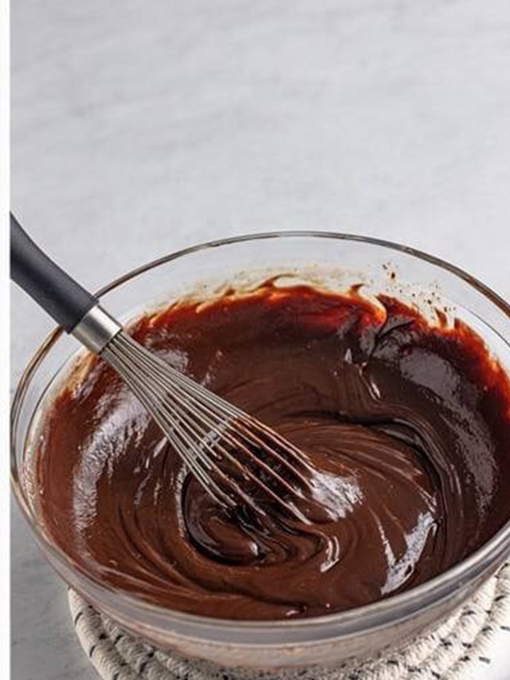 Baileys ganache whisked glossy and smooth in a glass bowl.