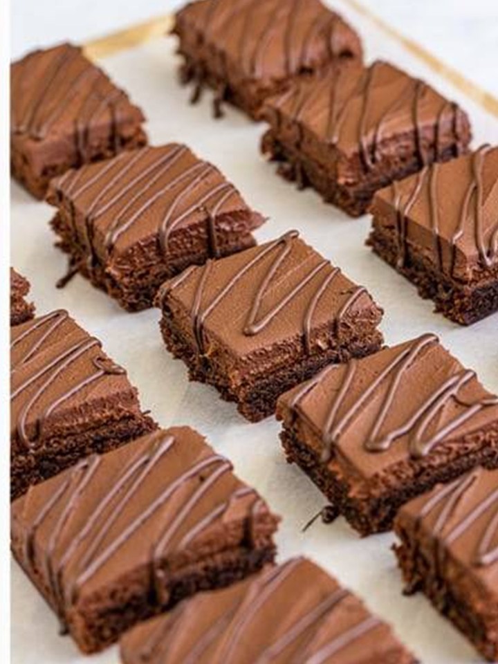 Baileys brownies cut into squares and drizzled with melted dark chocolate.