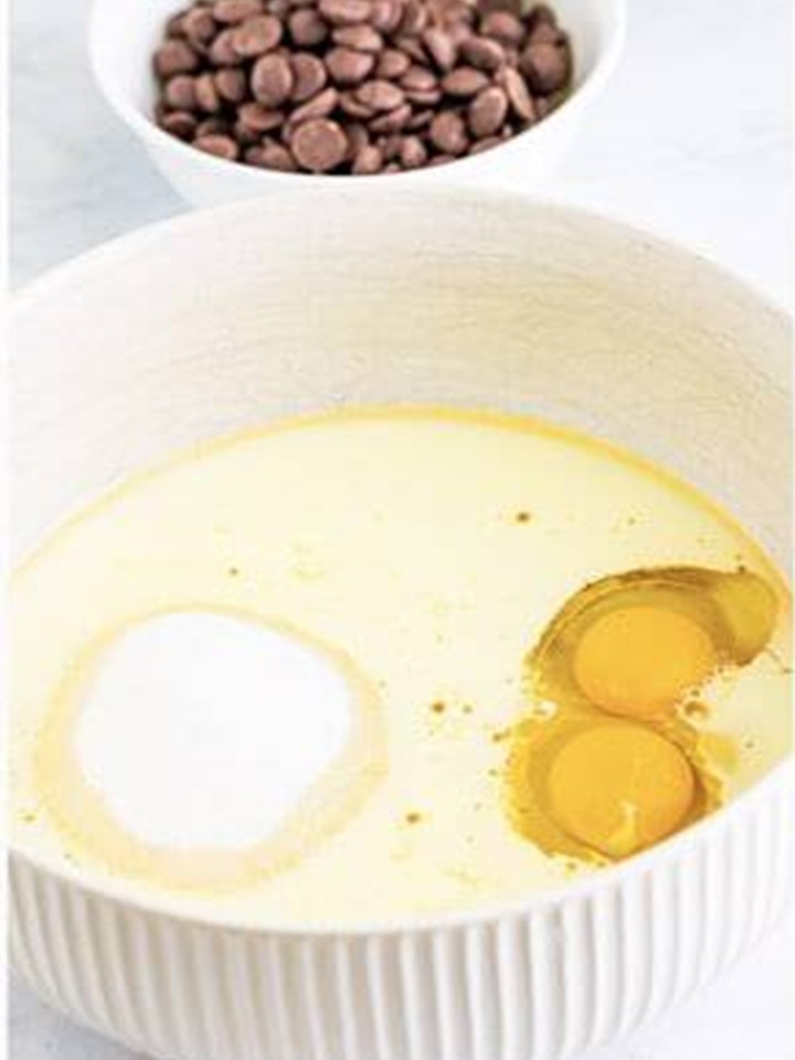 Sugar, milk, oil, eggs, and vanilla whisked together in a large bowl for baileys cupcakes.