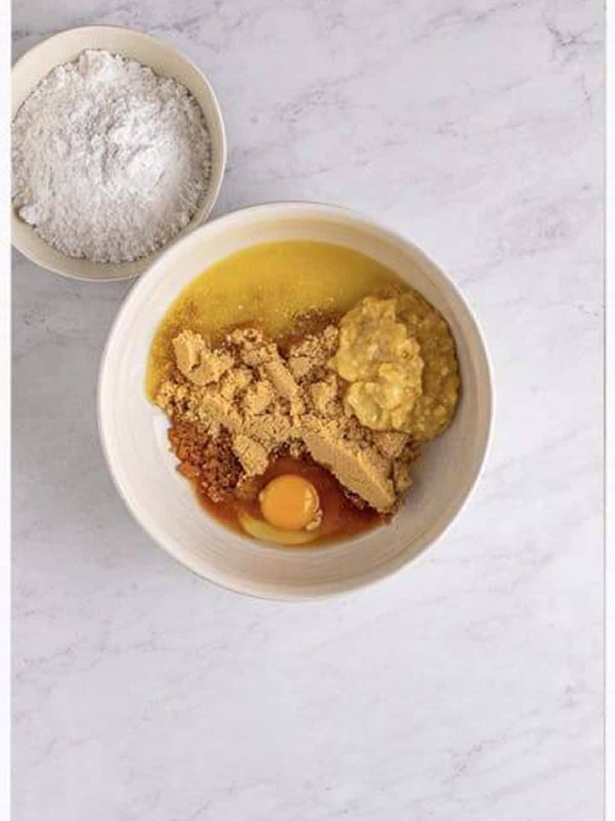 Melted butter, brown sugar, mashed banana, egg, and vanilla in a mixing bowl for Banana Blondies.