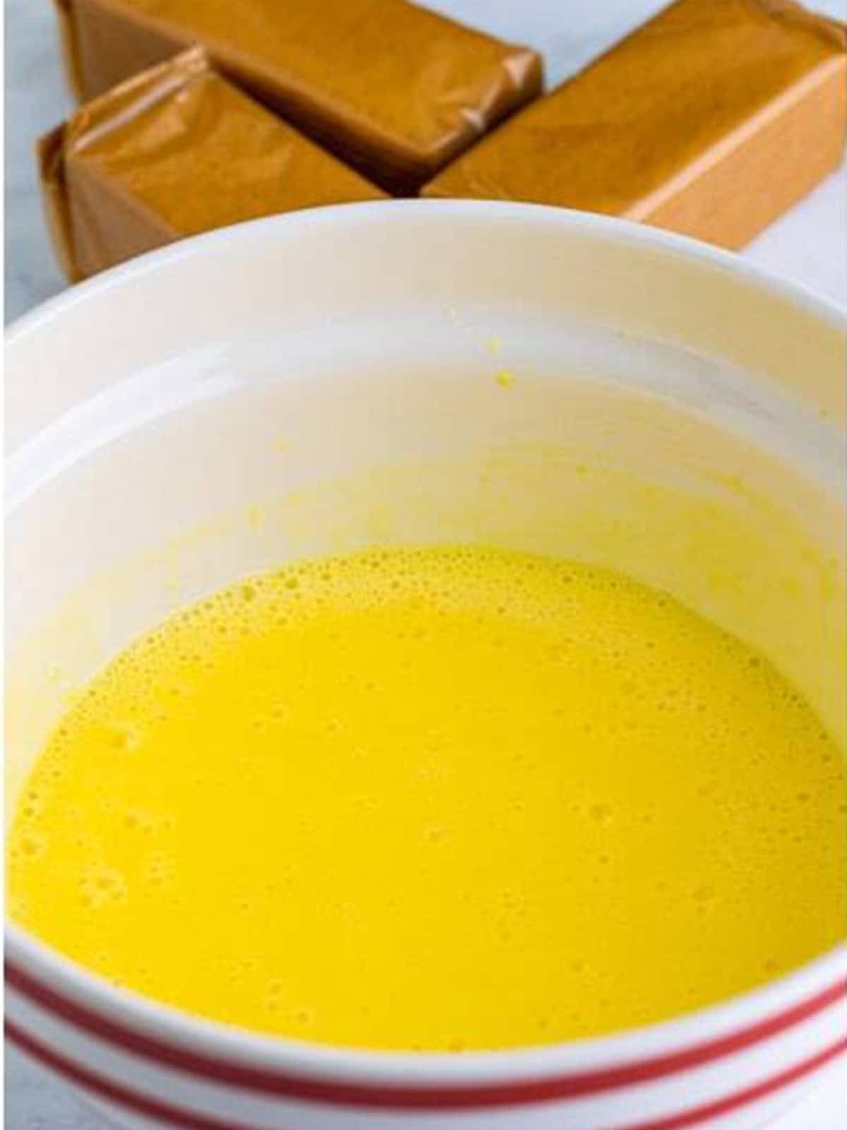 Banana pudding mix whisked with cold milk in a striped bowl.