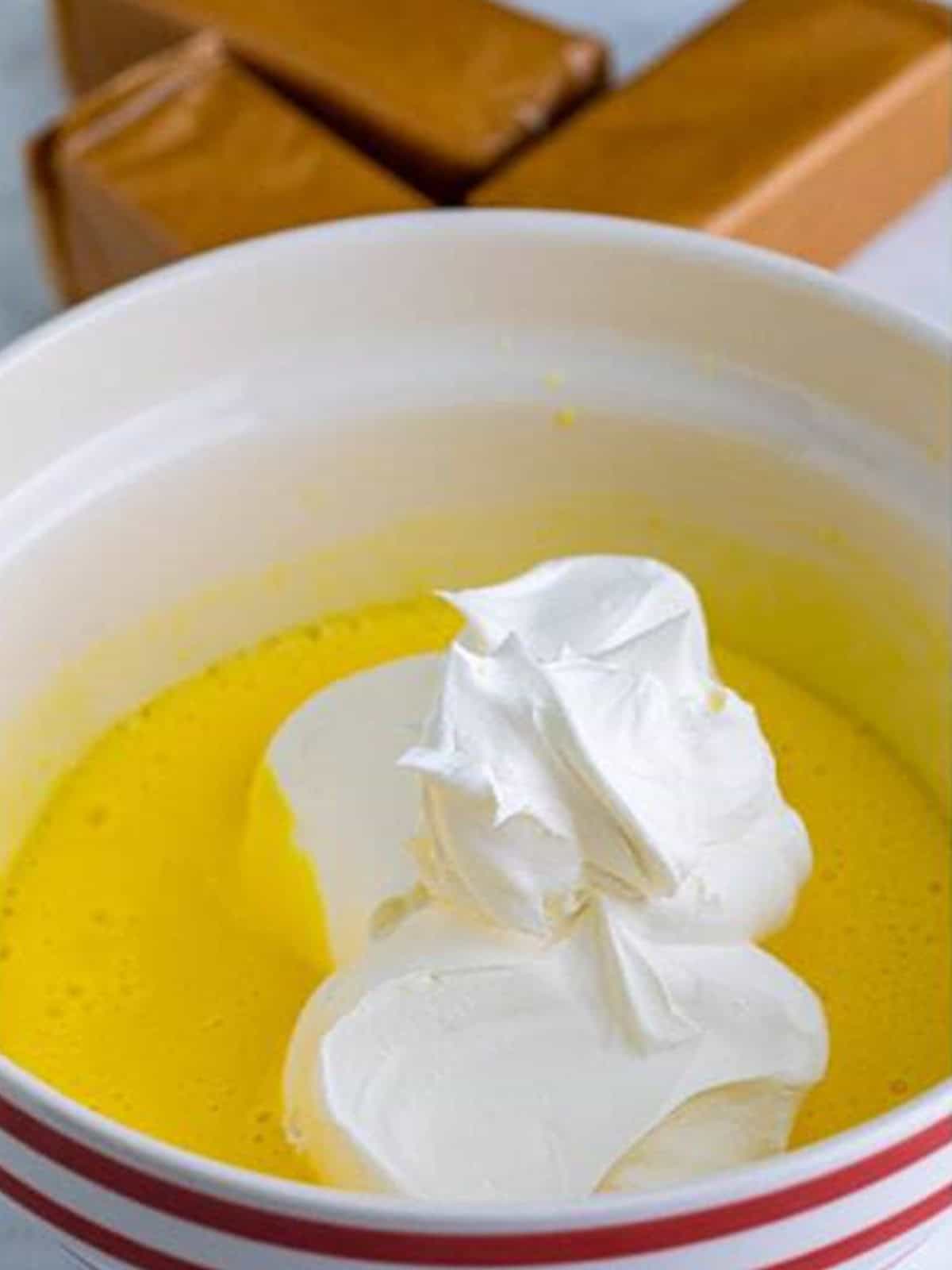 Whipped topping added to the banana pudding in a bowl.
