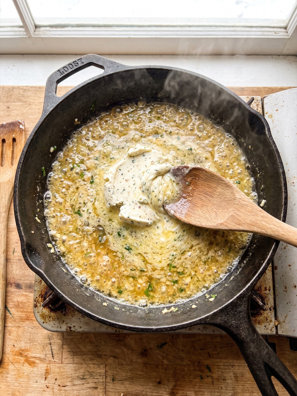 Garlic herb cheese melting into a creamy sauce.