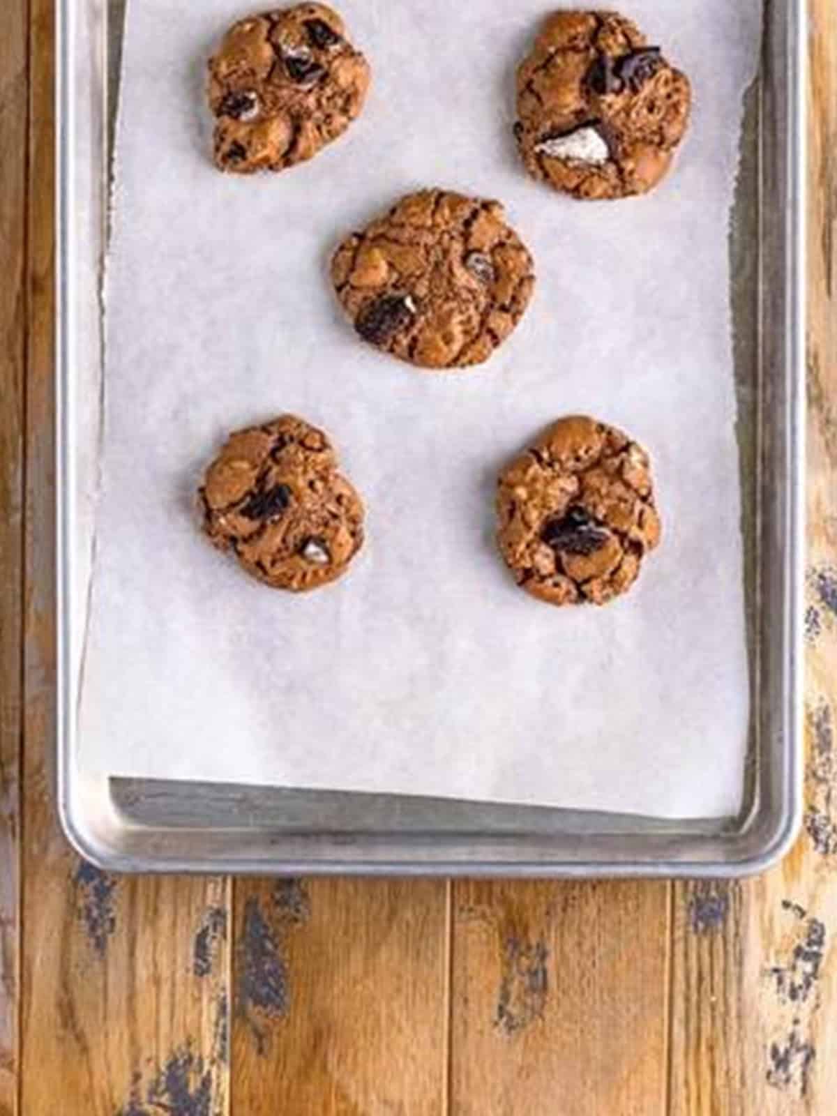 Brownie cookie dough scooped onto a parchment lined tray and garnished with chopped Oreos.