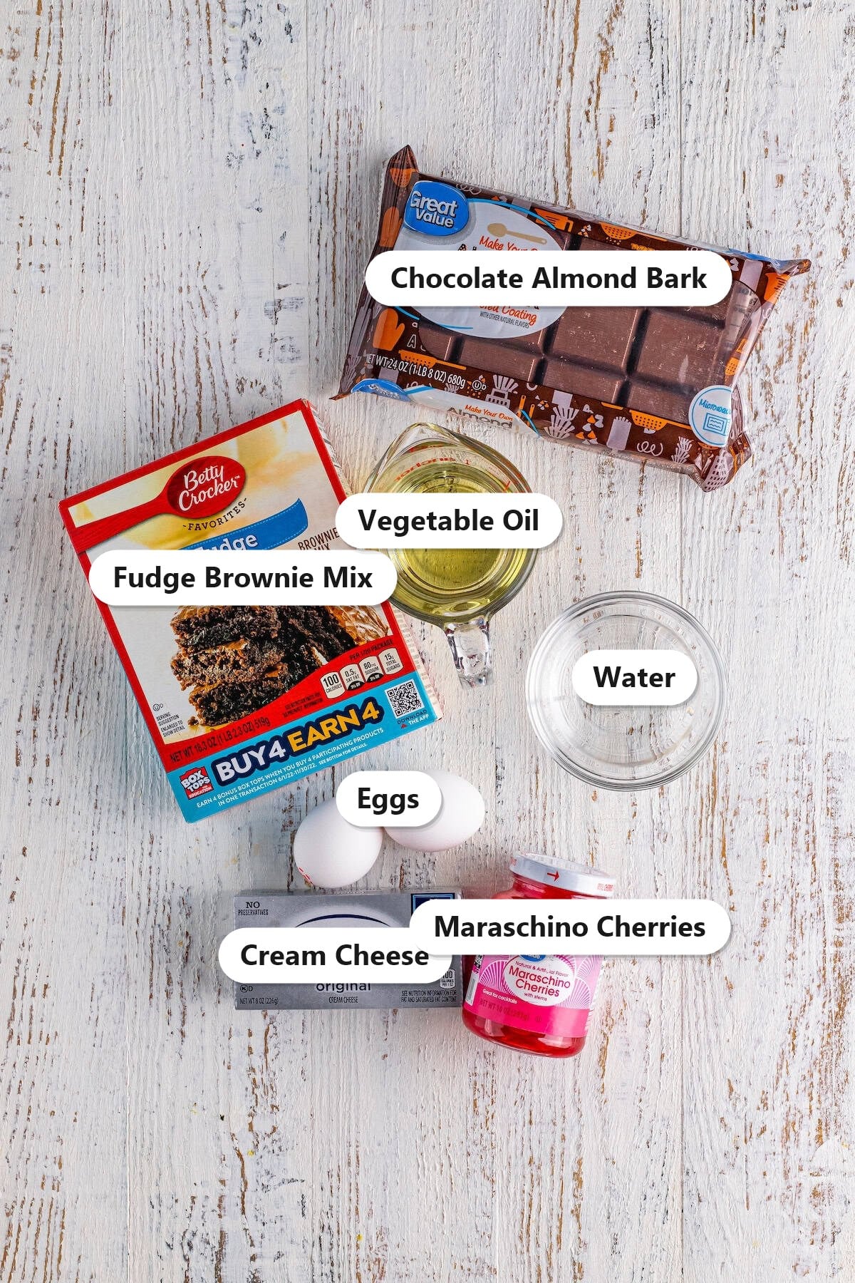 Labeled ingredients for brownie truffles including brownie mix, chocolate almond bark, eggs, oil, water, cream cheese, and maraschino cherries.