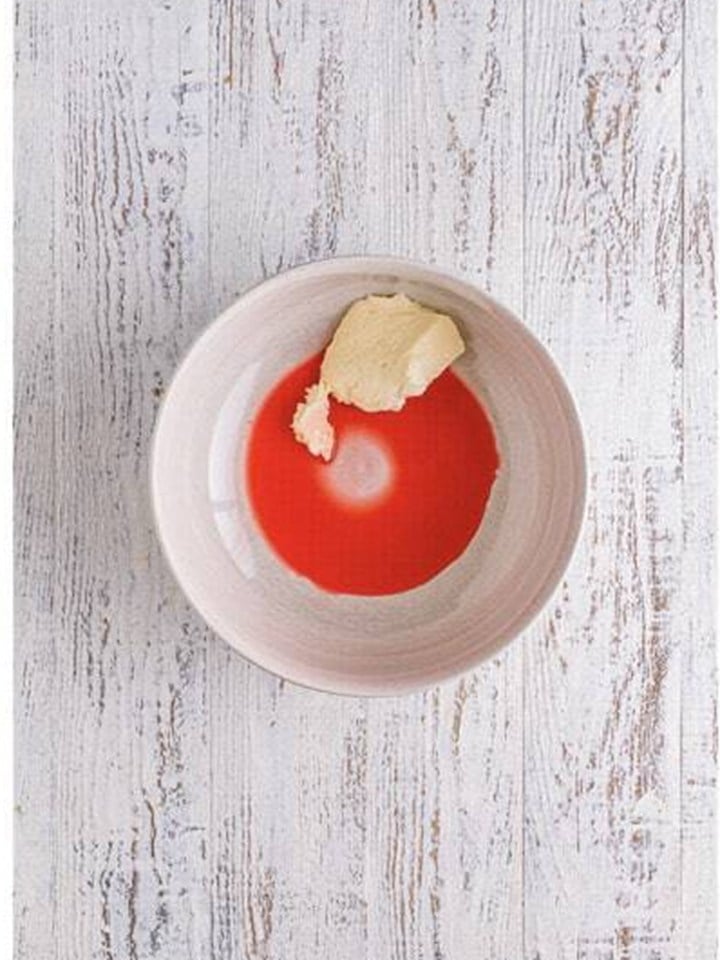 Cream cheese and maraschino cherry juice in a bowl for the brownie truffle mixture.