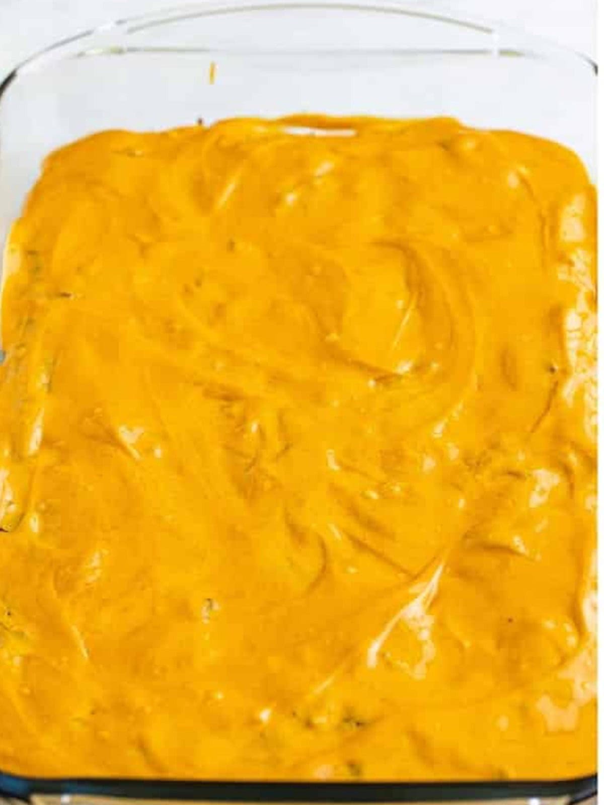 Melted peanut butter spread evenly over warm baked brownies.