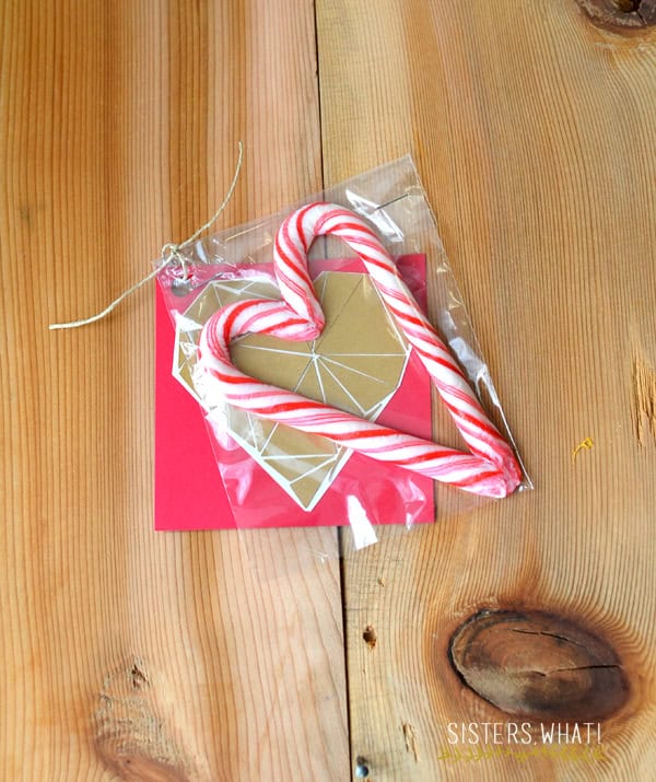 A candy cane heart packaged in a cellophane bag with a valentine card as a gift.
