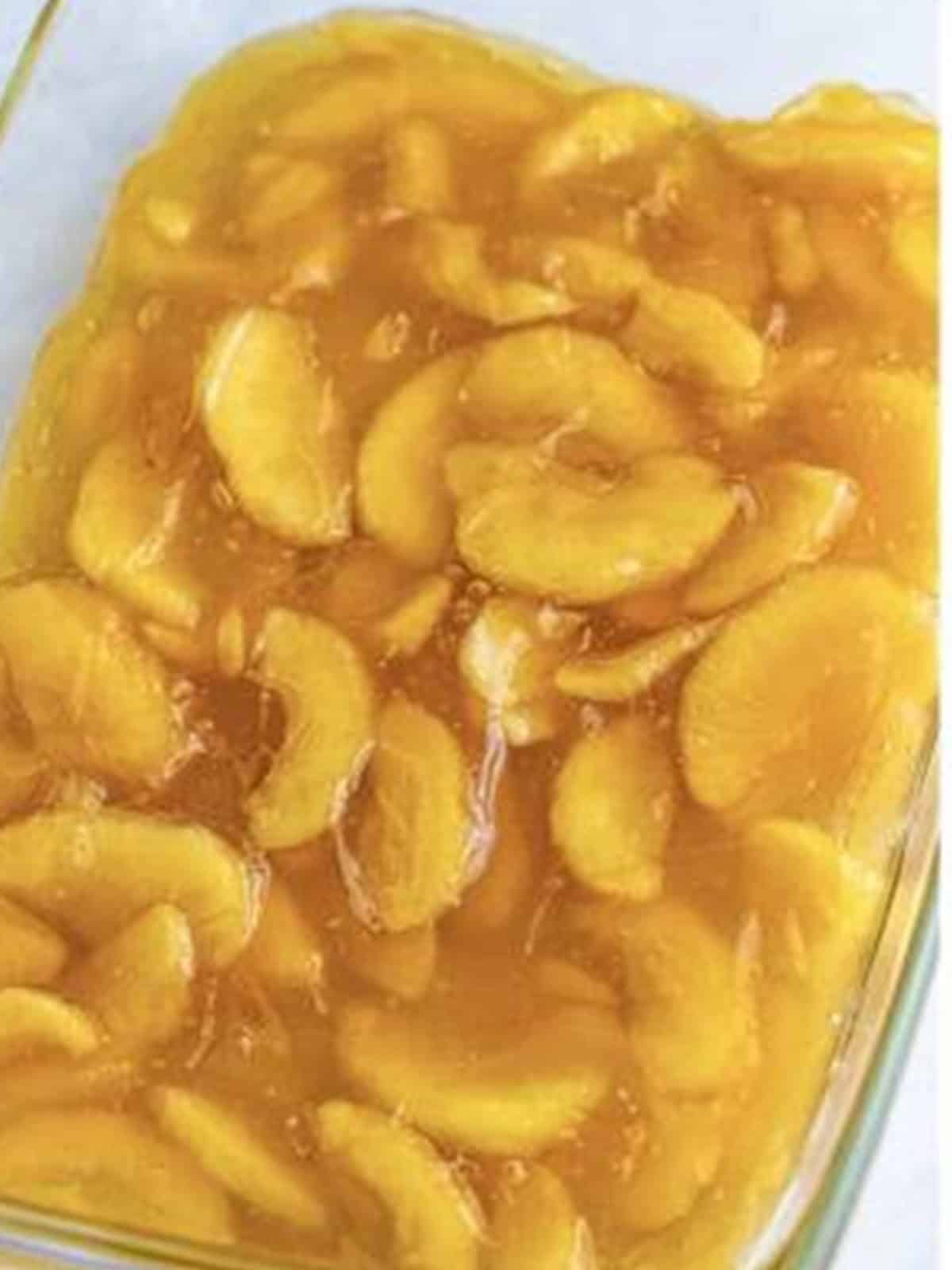 Apple pie filling spread in the bottom of a baking dish for caramel apple dump cake.