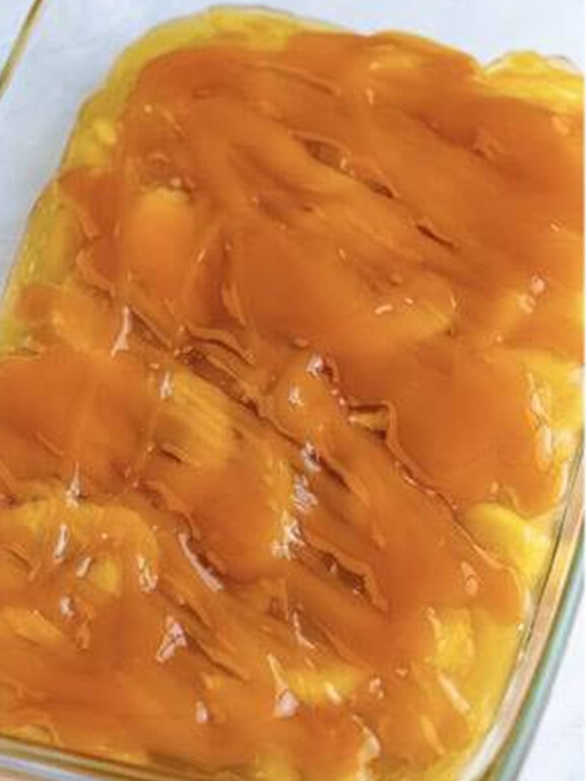 Caramel sauce drizzled over apple pie filling for caramel apple dump cake.