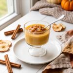 A cup of Caramel Apple Pudding topped with cinnamon applesauce.