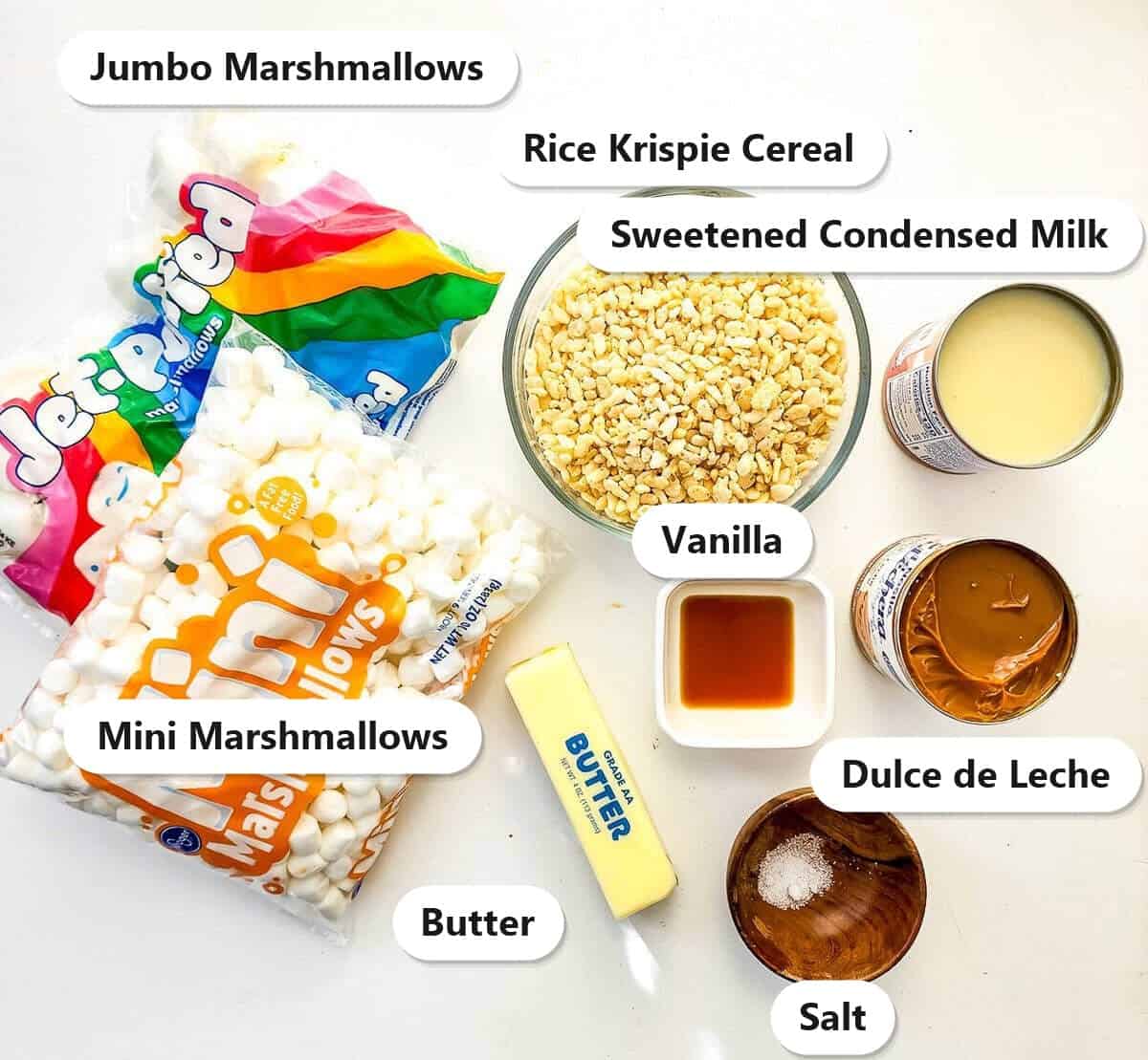 The ingredients for caramel rice krispie treats labeled, marshmallows, rice krispie cereal, butter, sweetened condensed milk, vanilla, salt, and dulce de leche.