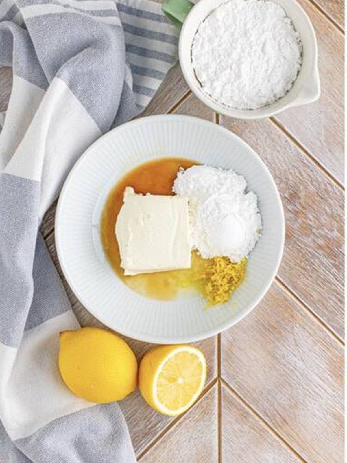 Mixing cream cheese, powdered sugar, lemon juice, vanilla, and lemon zest into a smooth cheesecake filling.