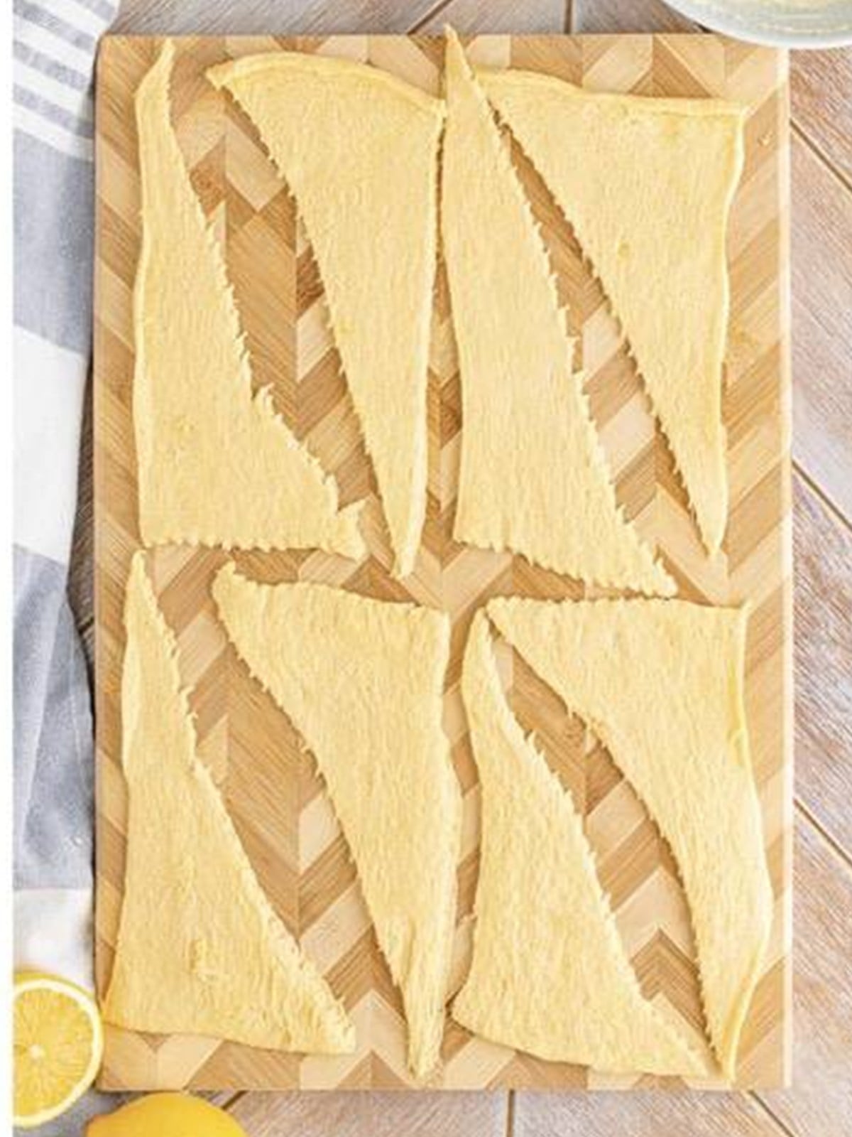 Spreading the lemon cheesecake filling onto each crescent roll triangle.
