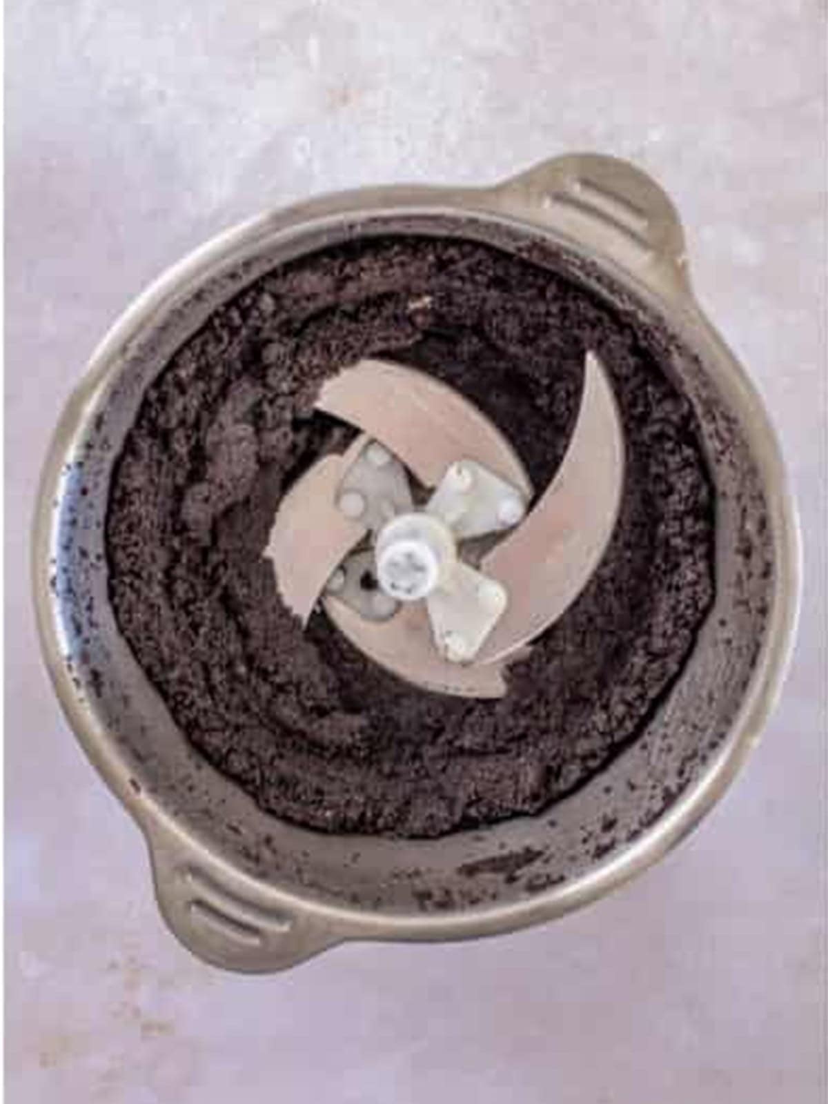 Oreo cookies processed into fine crumbs in a food processor.