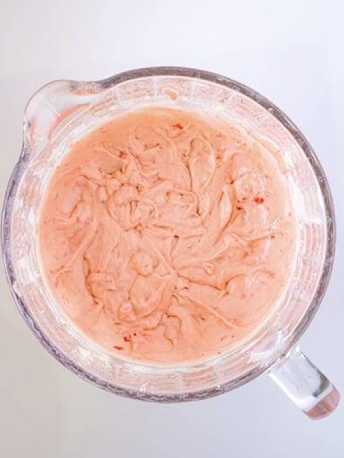 Pink cherry cupcake batter with blended maraschino cherries folded through.