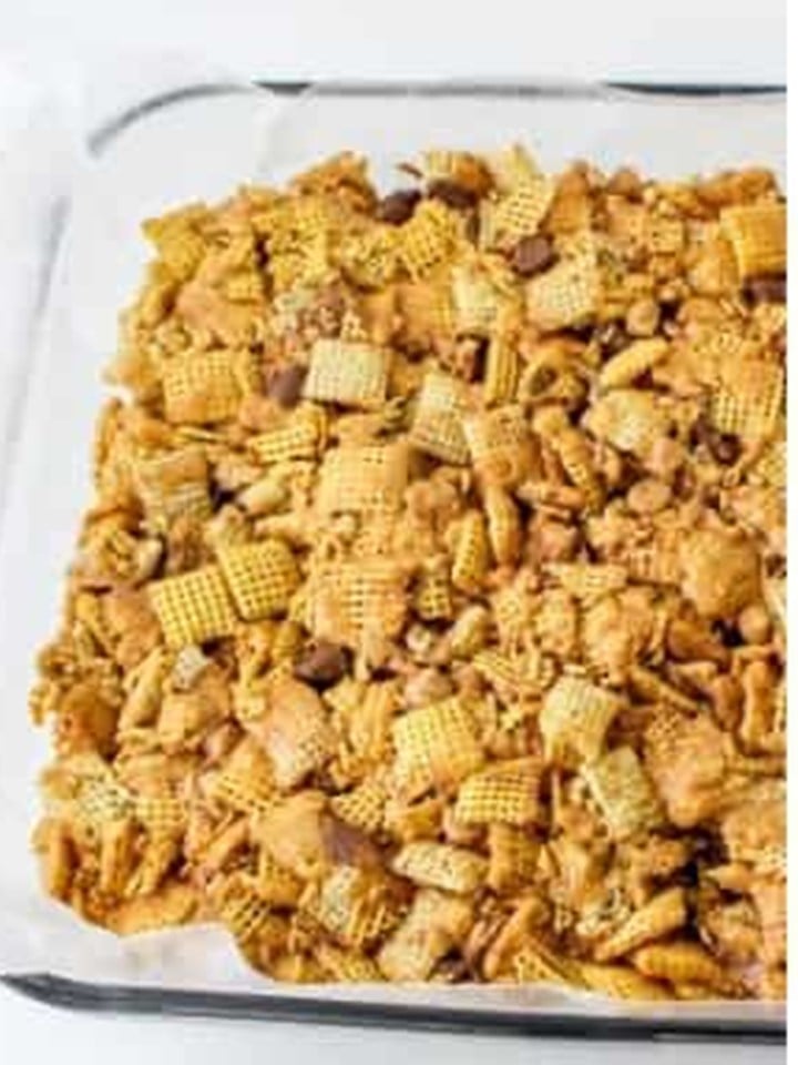 The chex bar mixture pressed firmly into a parchment lined 9x13 baking dish.