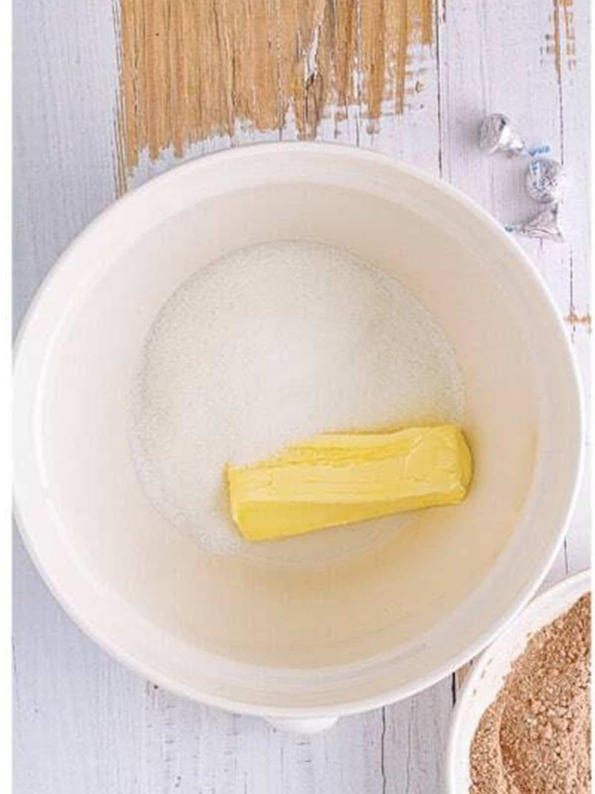 Butter and granulated sugar in a mixing bowl ready to cream for chocolate blossom cookies.
