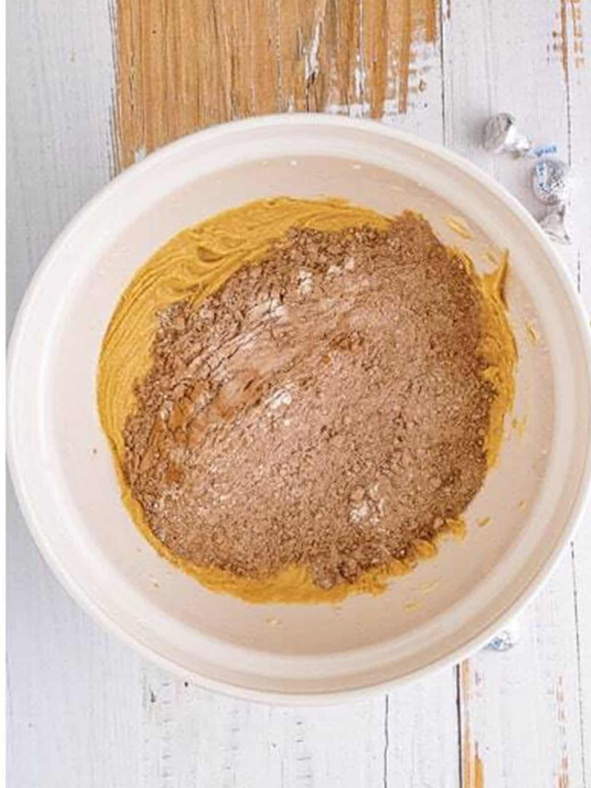 Mixing the cocoa flour mixture into the peanut butter dough.