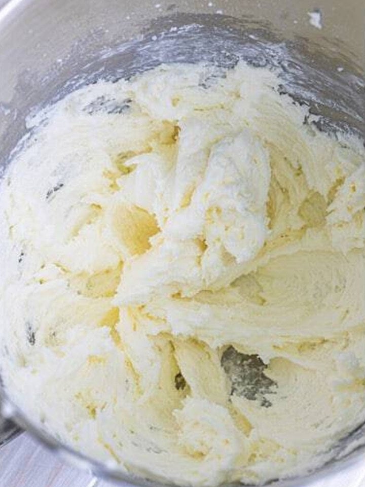 Powdered sugar and milk mixed into whipped butter until smooth for chocolate buttercream frosting.