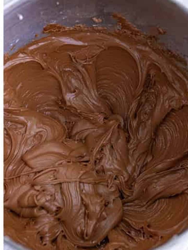 Finished chocolate buttercream frosting whipped smooth and glossy in a stand mixer bowl.