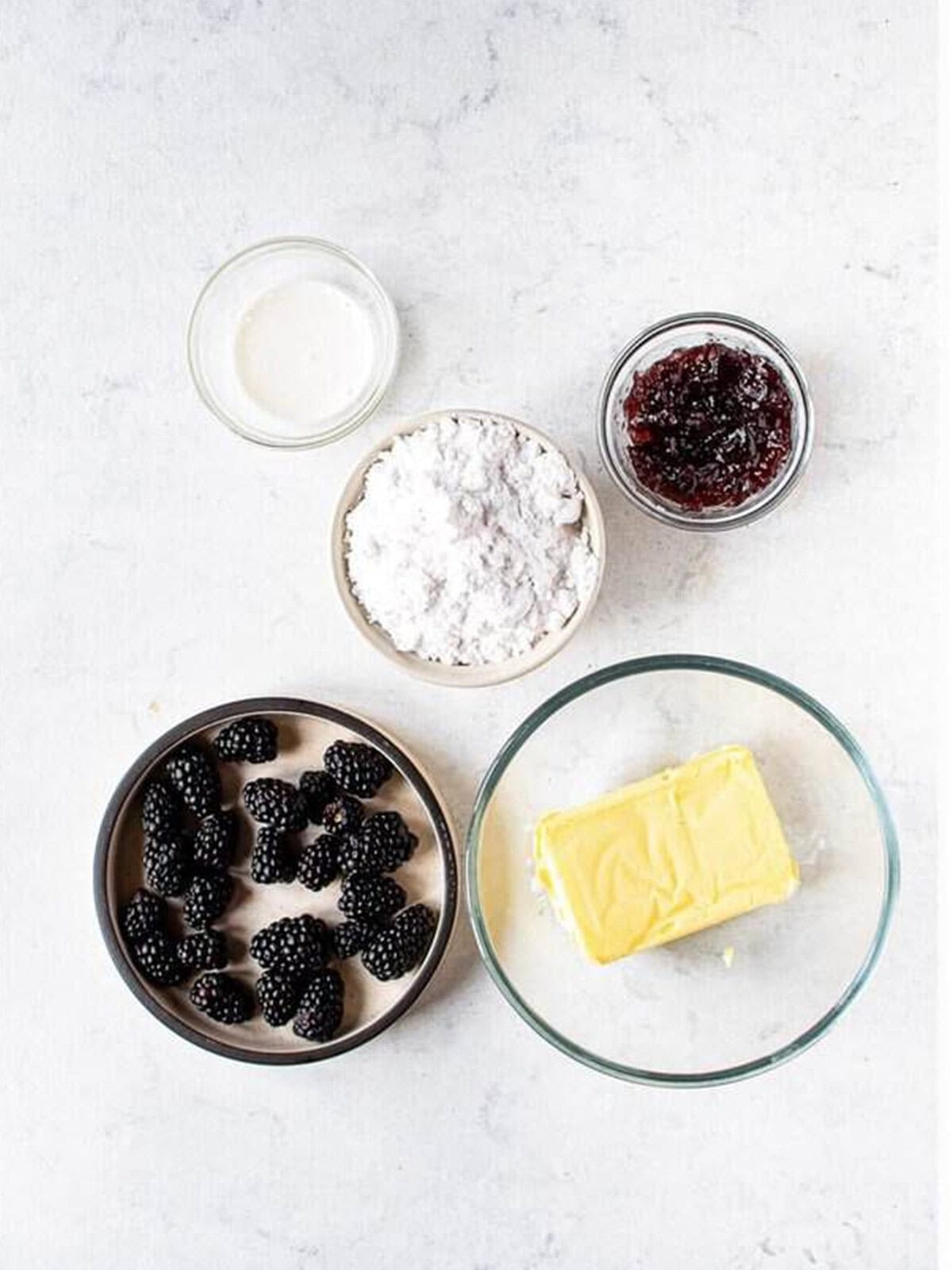Butter, powdered sugar, blackberry preserves, and cream ready to whip into blackberry buttercream.