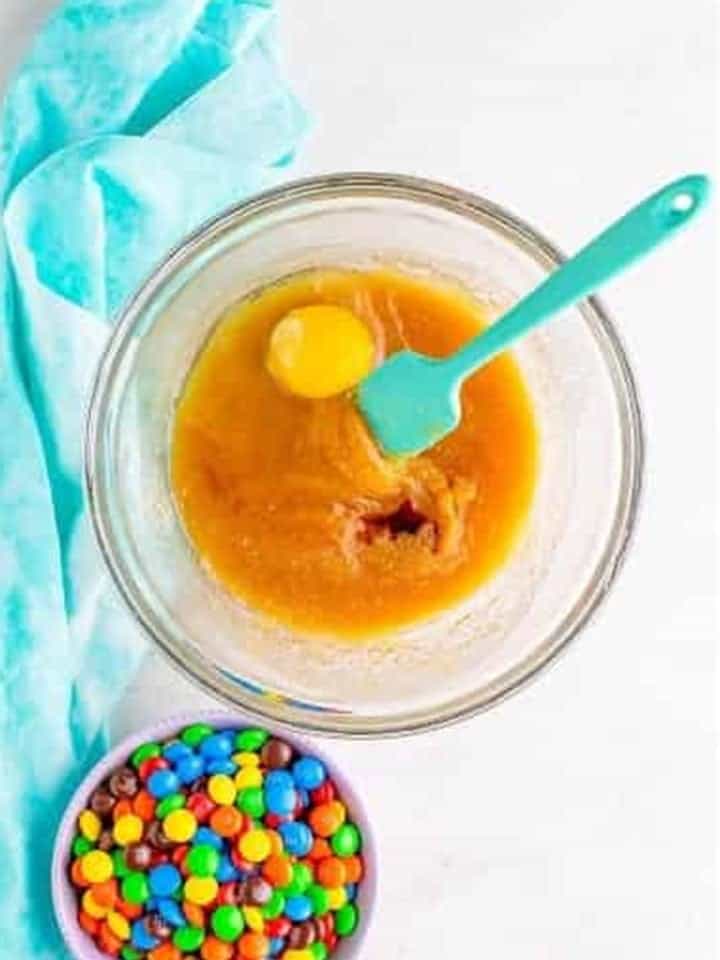 Egg and vanilla added to the butter and sugar mixture for chocolate m&m cookies.