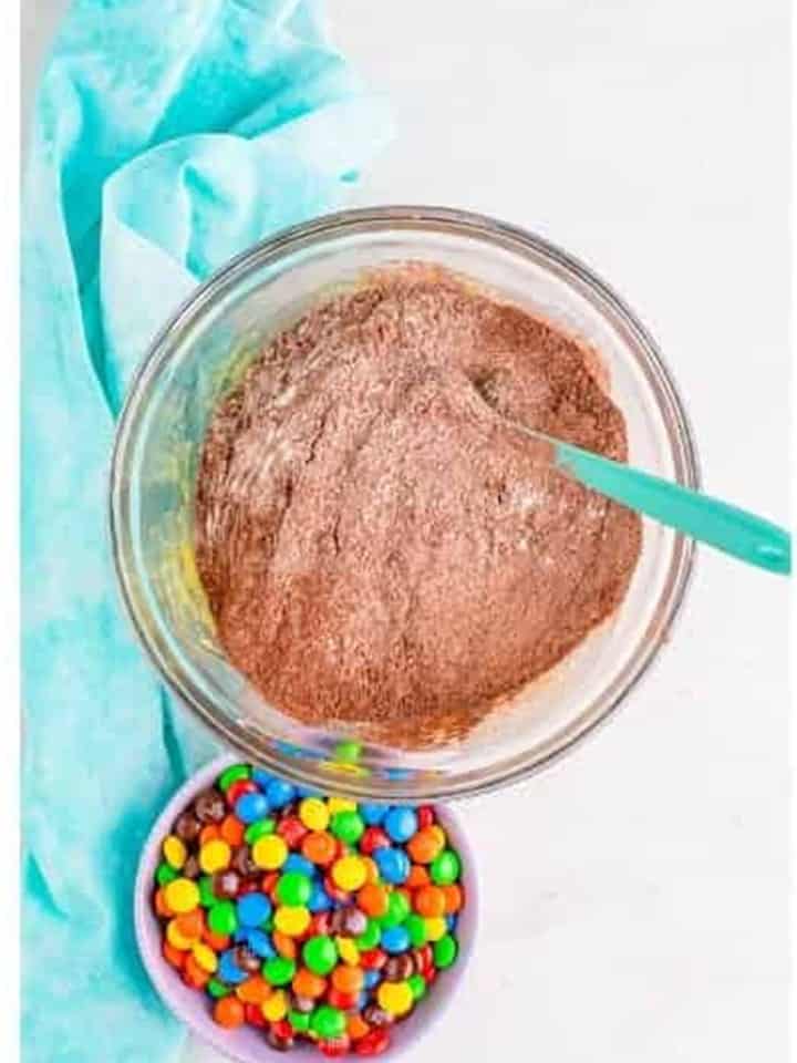The chocolate dry mix stirred into the wet ingredients for chocolate m&m cookies dough.