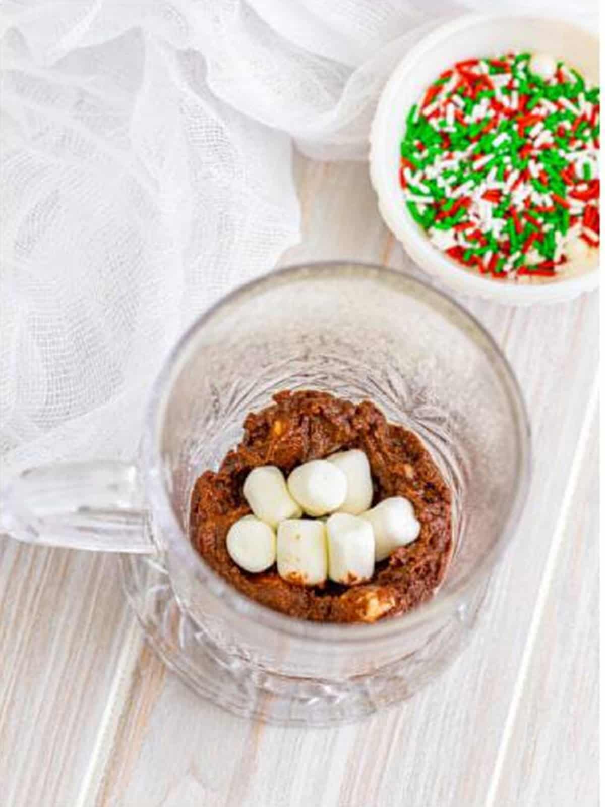 Mini marshmallows placed into the pocket of batter in the mug.