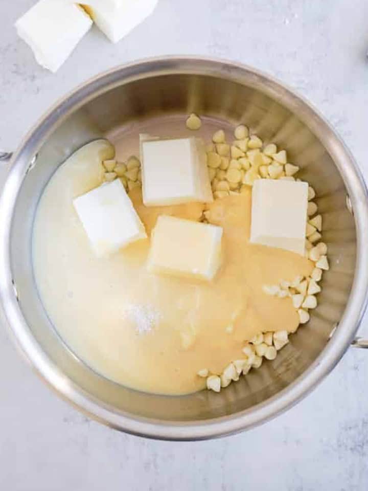 White chocolate chips, almond bark, and sweetened condensed milk combined in a double boiler for christmas fudge.