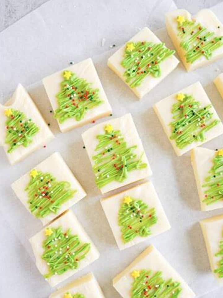 Finished christmas fudge squares decorated with green trees, star sprinkles, and holiday sprinkles.