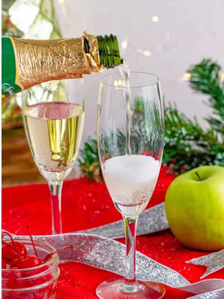 Sparkling white grape juice being poured halfway into a champagne flute for Christmas Mocktails.