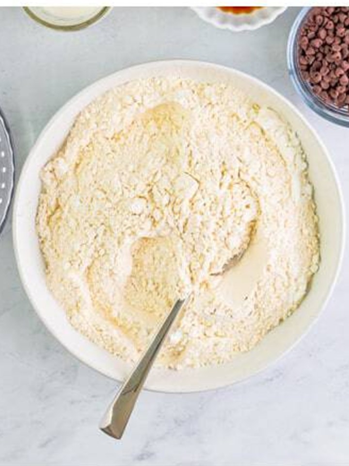 Flour, cornstarch, baking soda, and salt stirred together for christmas sandwich cookies.