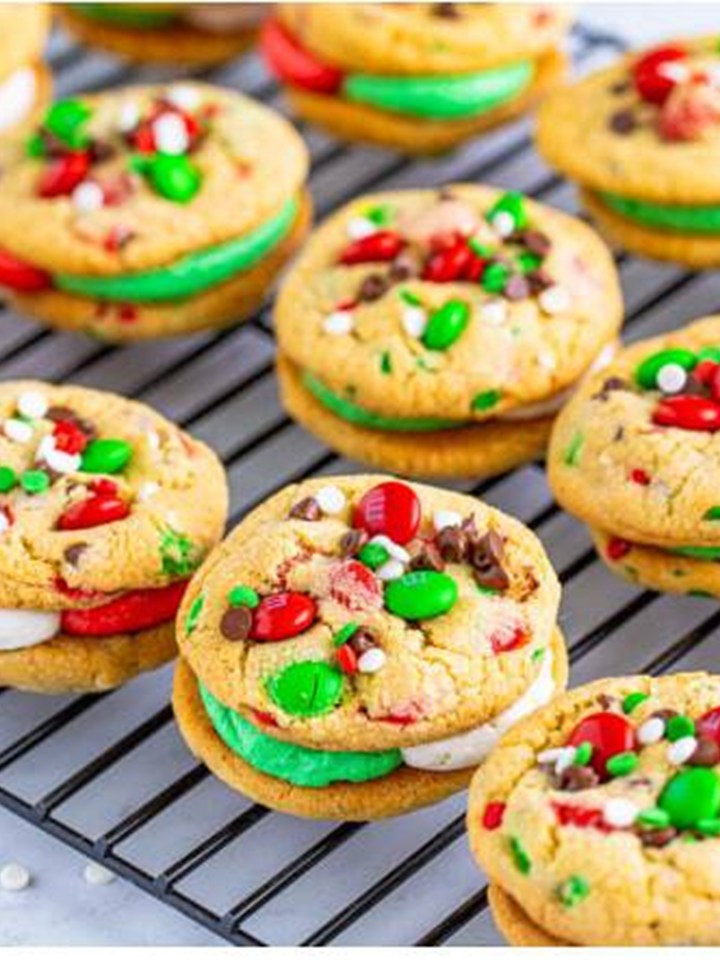 Assembled christmas sandwich cookies on a wire rack showing the colorful frosting centers.