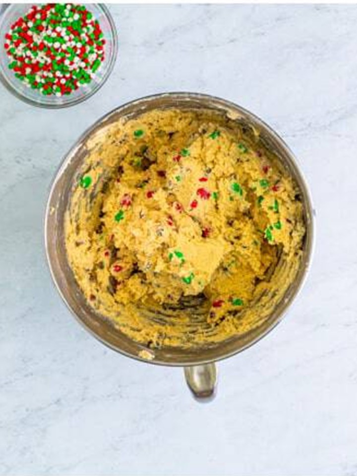 The candies stirred through the christmas sandwich cookie dough.