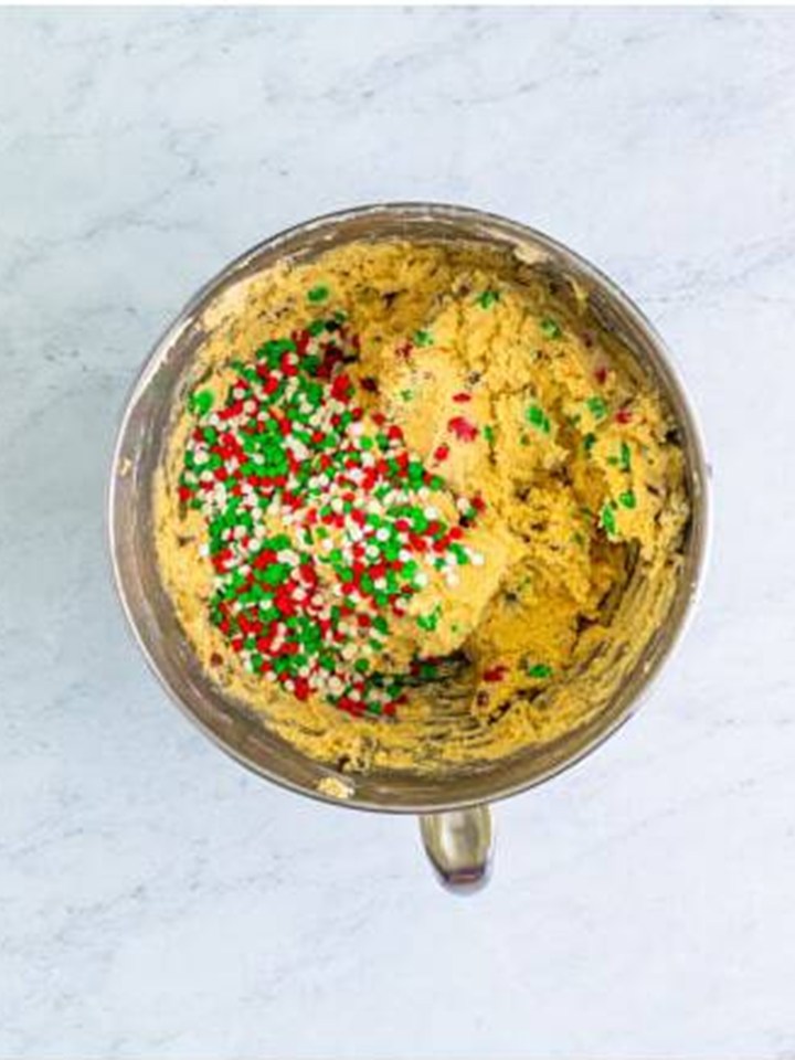Holiday sprinkles added to the cookie dough in the mixer bowl.