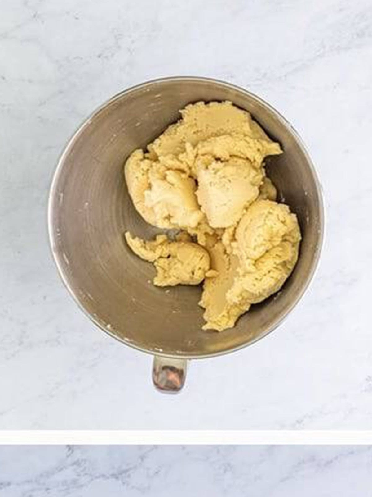 Smooth shortbread cookie dough in the mixer bowl after adding the vanilla and flour.