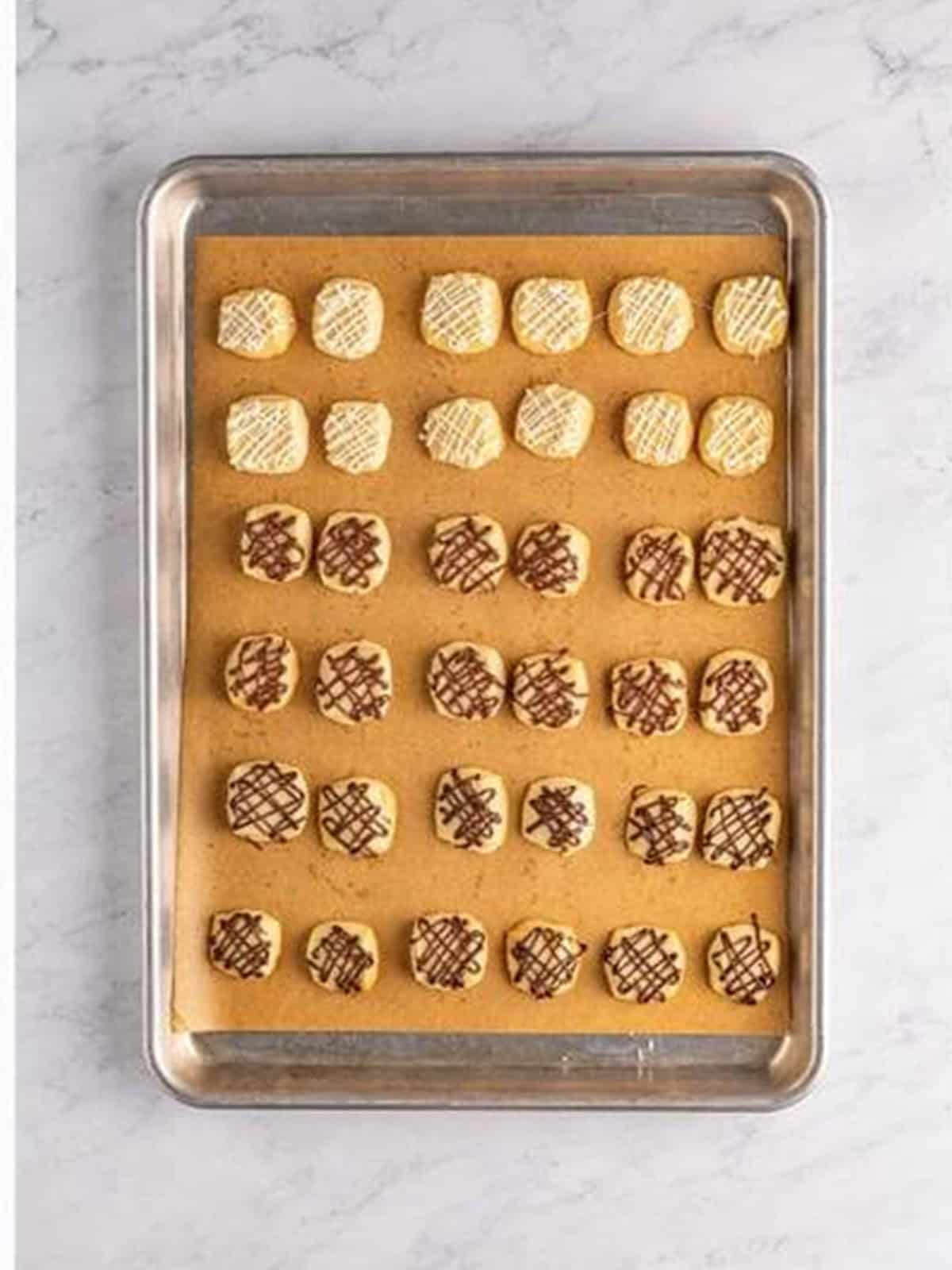 Drizzling melted dark, milk, and white chocolate over the cooled Christmas shortbread cookie bites.
