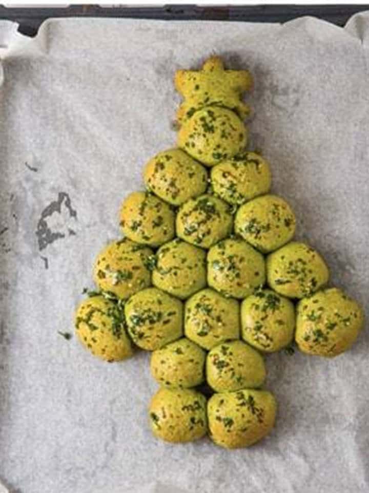 Baked golden Christmas Tree Pull Apart Bread brushed with herb butter on the tray.