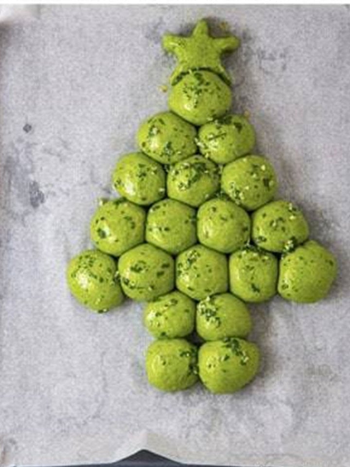 Risen Christmas tree dough balls brushed generously with garlic parsley butter.